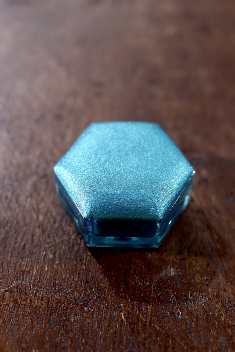 Holographic watercolor close-up showing prismatic light-reactive shimmer in a Lisilinka Opal pan