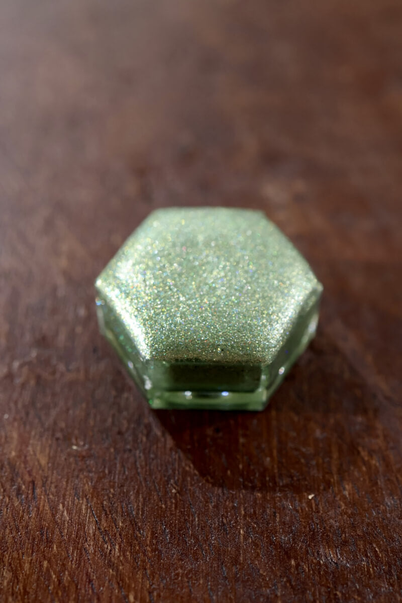 Holographic watercolor close-up showing prismatic light-reactive shimmer in a Lisilinka Opal pan