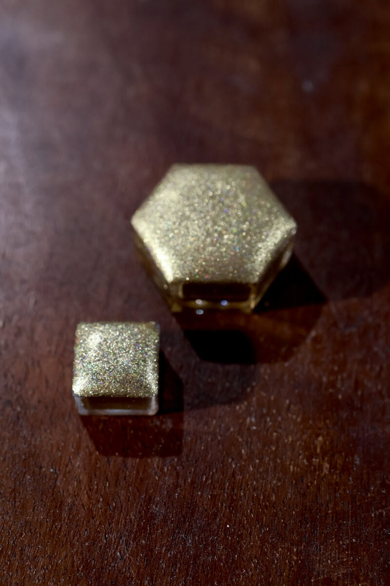 Size comparison: Lisilinka Opal mini pan and custom hexagon pan side by side, both filled with handmade holographic watercolor