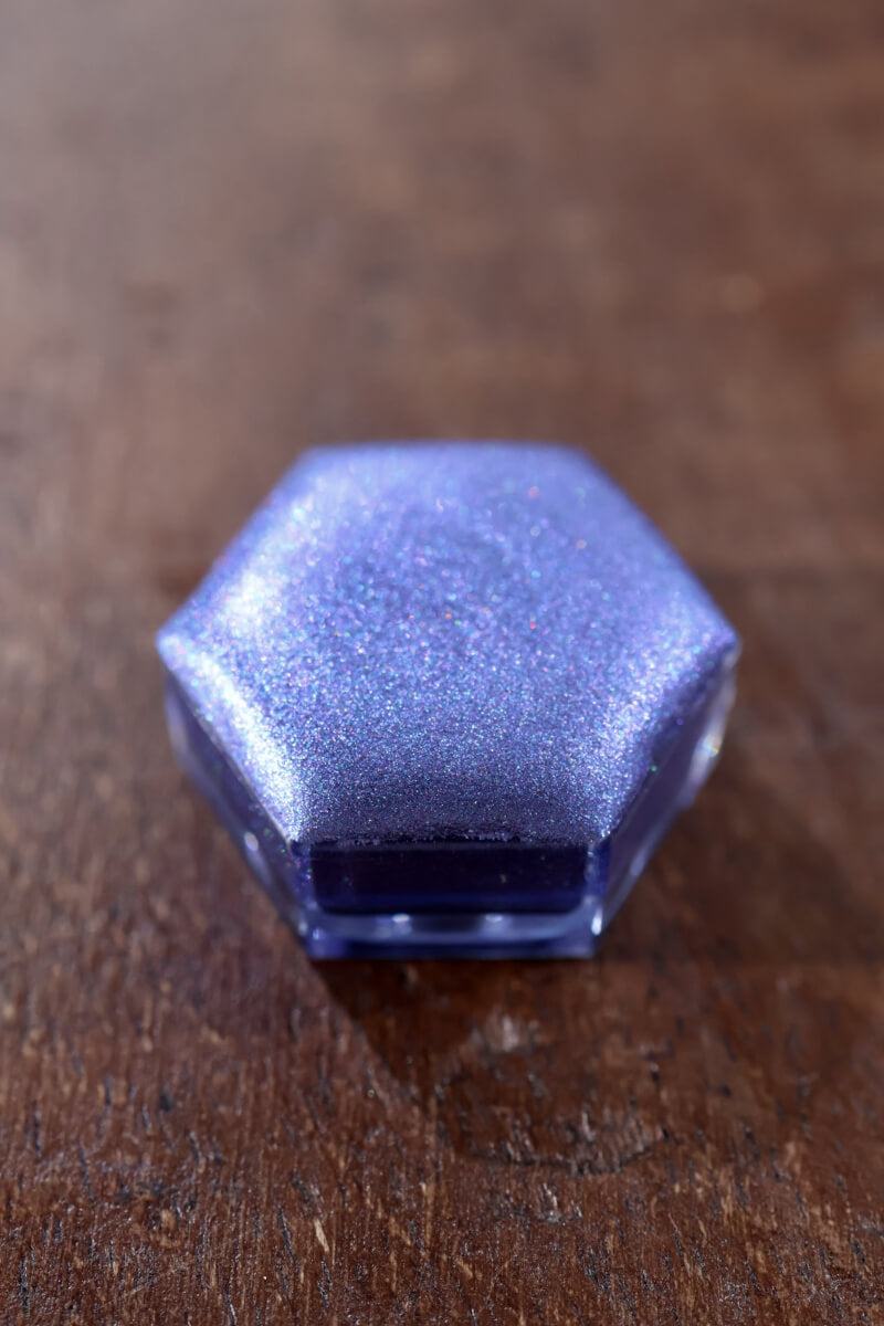 Holographic watercolor close-up showing prismatic light-reactive shimmer in a Lisilinka Opal pan